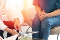 woman pointing at ipad and other woman sitting next to her hands folded together Unveiling the Impact of Strategic Leadership in Administrative Studies: A Doctoral Perspective