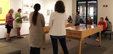 people in gallery looking at artwork and listening to gallery talk