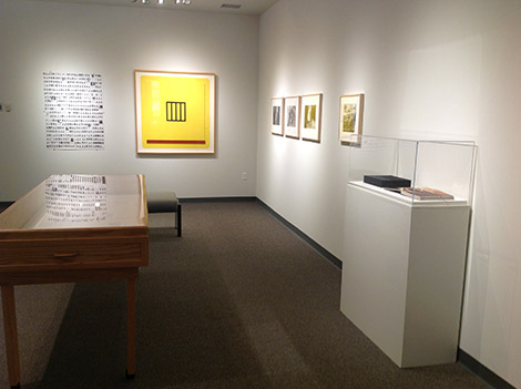 framed artwork on wall next to display case