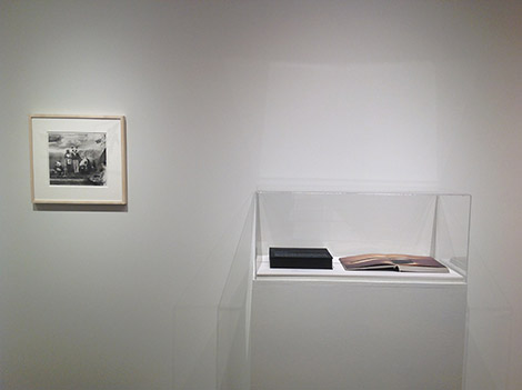 framed artwork on wall next to display case