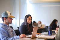 students sitting at desk with laptops in class
