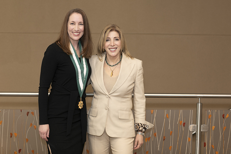 two ladies standing one with a medal around her
